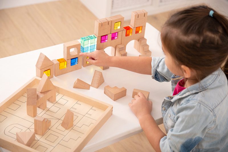 Les blocs de fenêtre en bois défient le jeu créatif et ouvert. Les blocs d’acrylique en vrac peuvent être ajoutés aux structures comme, par exemple, des fenêtres.