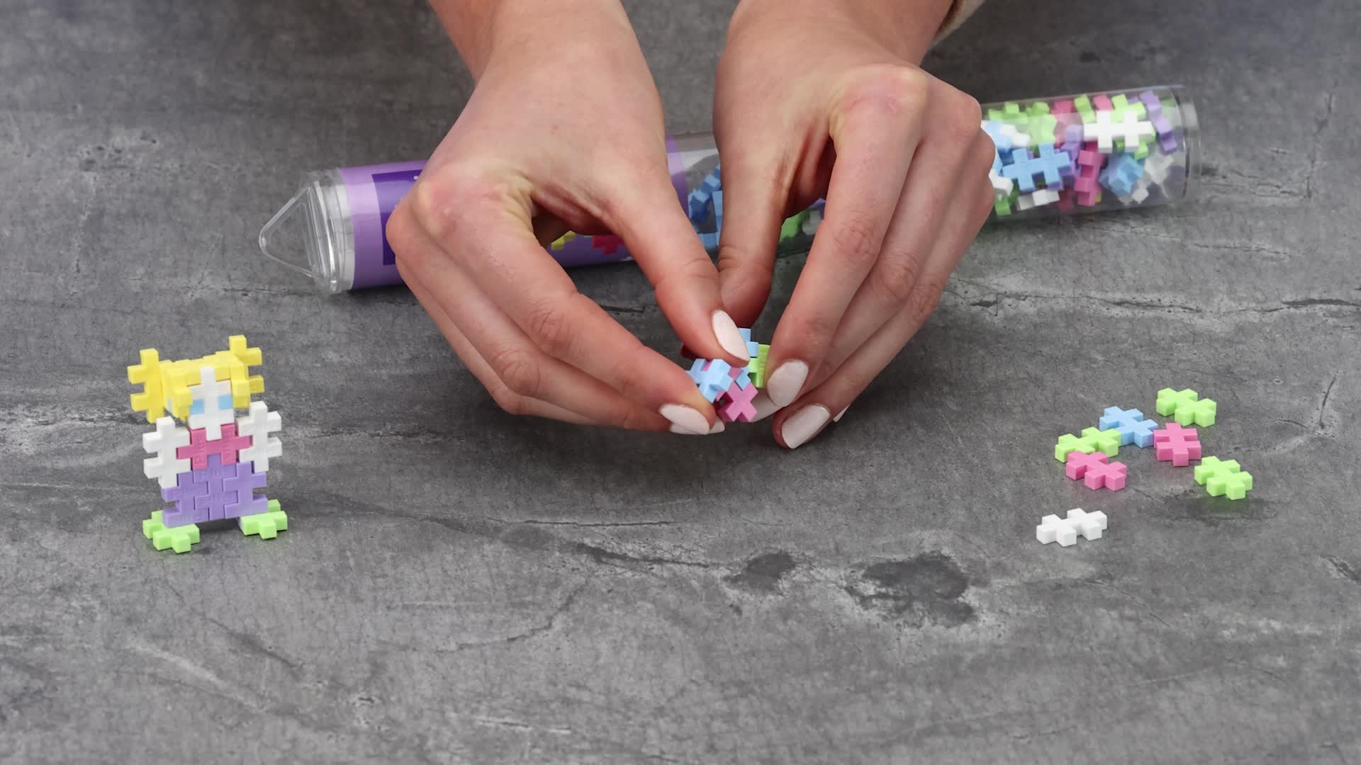 Kinderen stimuleren hun creativiteit en fijne motoriek terwijl ze bouwen met de zachte kleuren van de Plus-Plus Pastel Tube.
